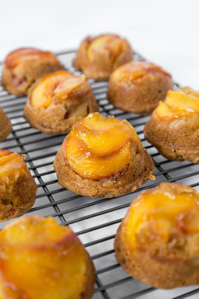 Mini Peach Upside Down Cakes on a wire cooling rack