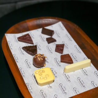 8 different chocolates displayed on a wooden tray