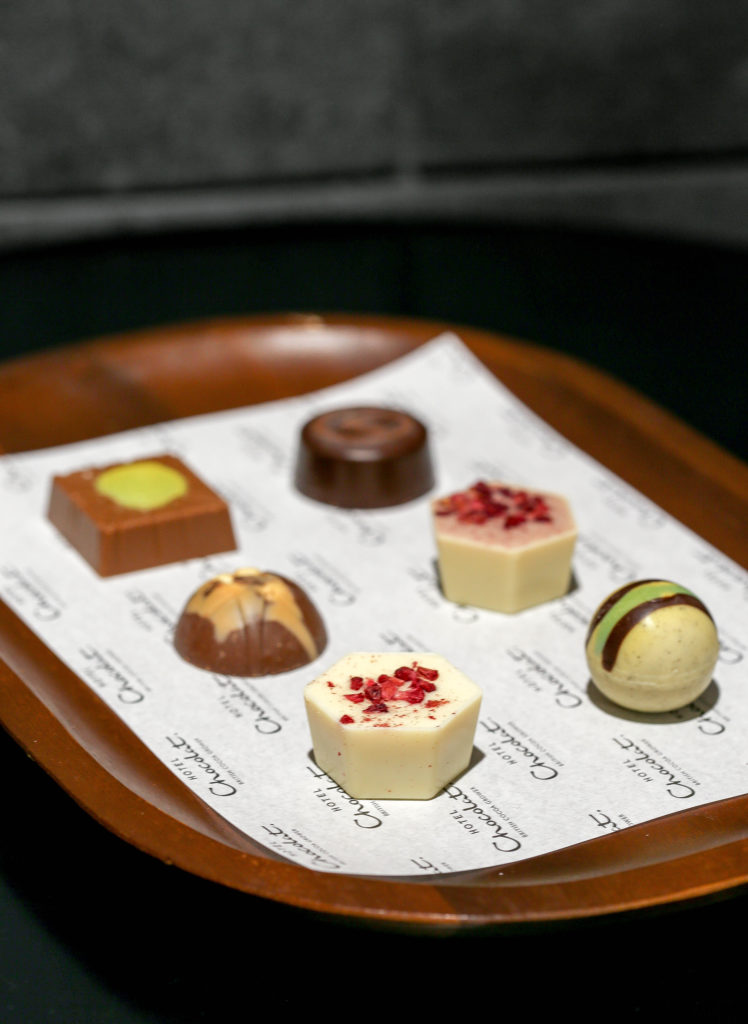 6 fancy chocolates displayed on a wooden tray