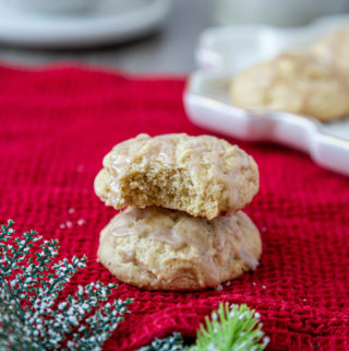 two eggnog cookies, one sitting on top of the other on a red kitchen towel