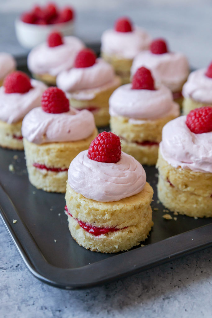 Mini raspberry cakes sitting on a metal tray.  