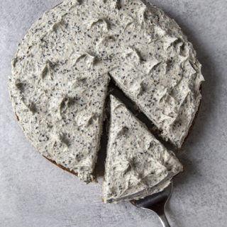Bird's eye view of black sesame cake with one slice cut on a grey background
