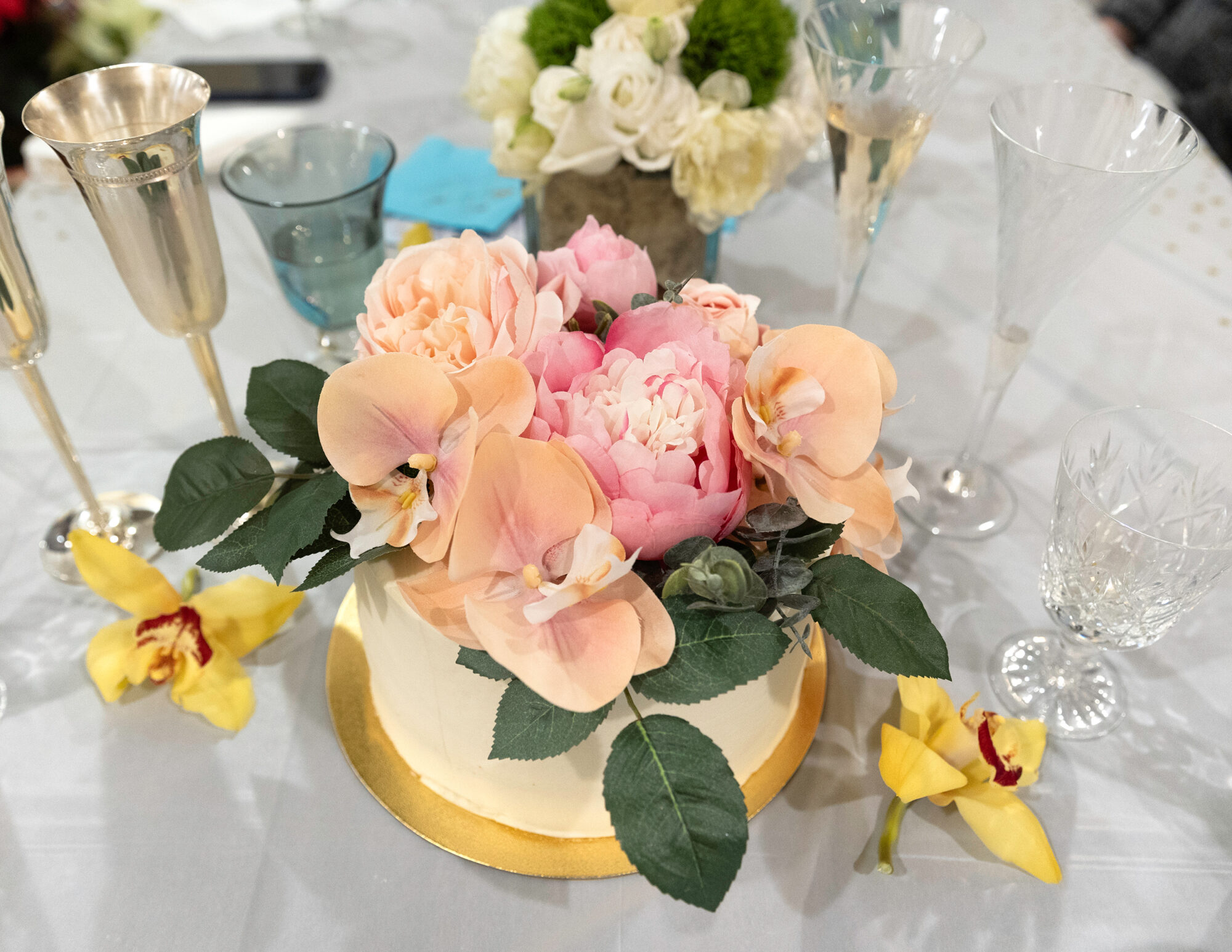 Top view of a wedding cake with pink and peach colored flowers.